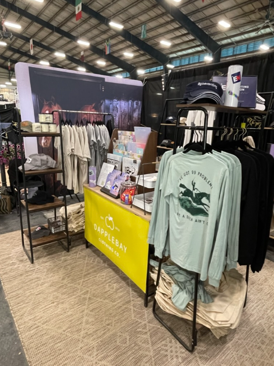 Clothing store interior with racks of clothes and a counter displaying products.
